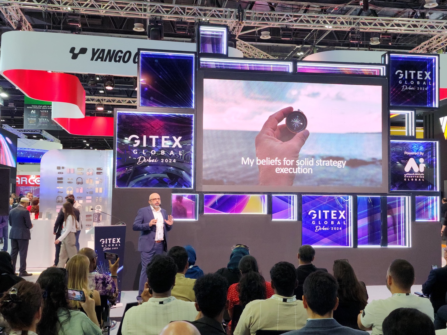 Ahmed speaking at GITEX Global Dubai 2024, with the audience and strategy execution presentation visible